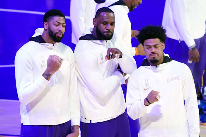 Los Angeles Lakers players Anthony Davis (left) and LeBron James (middle) and Quinn Cook (right) pose with 2020 NBA Championship rings before a game against the Los Angeles Clippers at Staples Center.